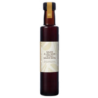 Bottle of black garlic sauce with a white label on a white background