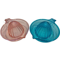 Two glass citrus reamers, one pink and one blue, on a white background.